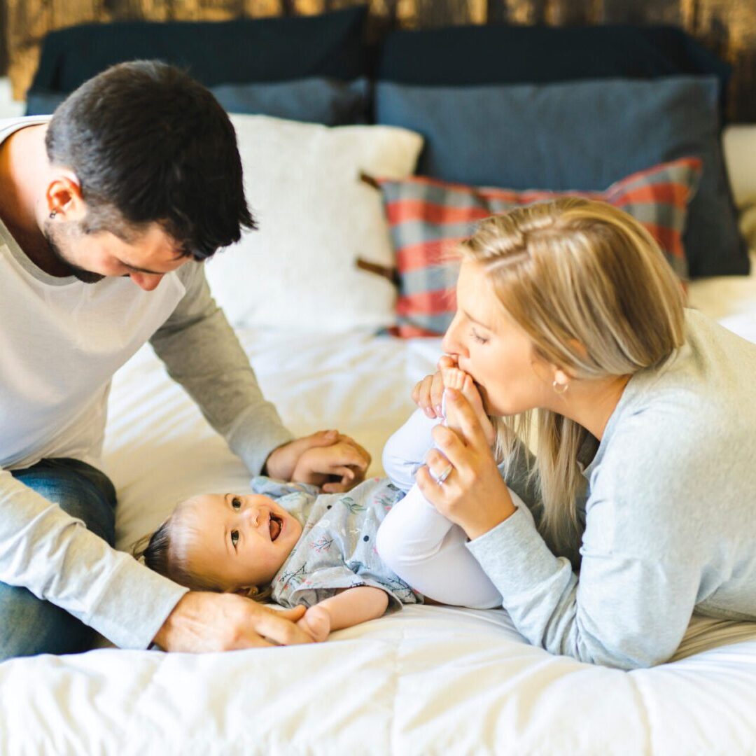 Parents playing with baby representing IVF through fresh egg donation
