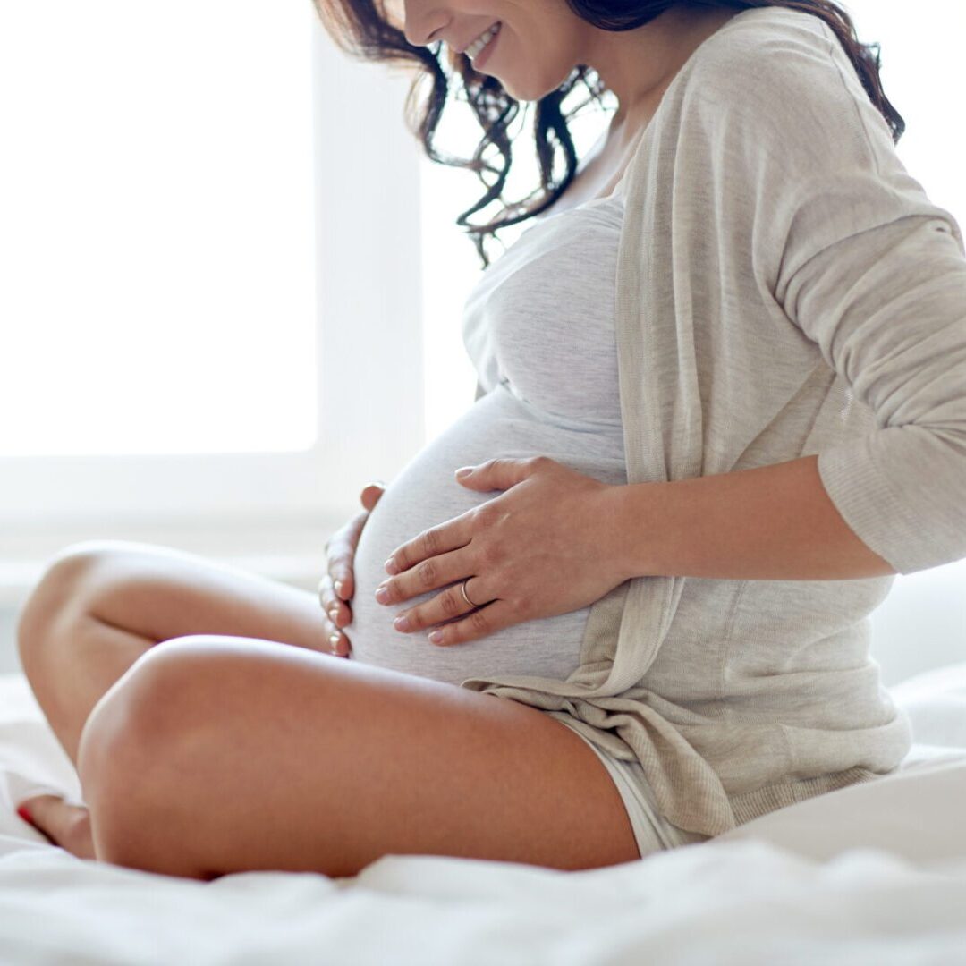 Expectant mother holding her belly, representing a gestational surrogate